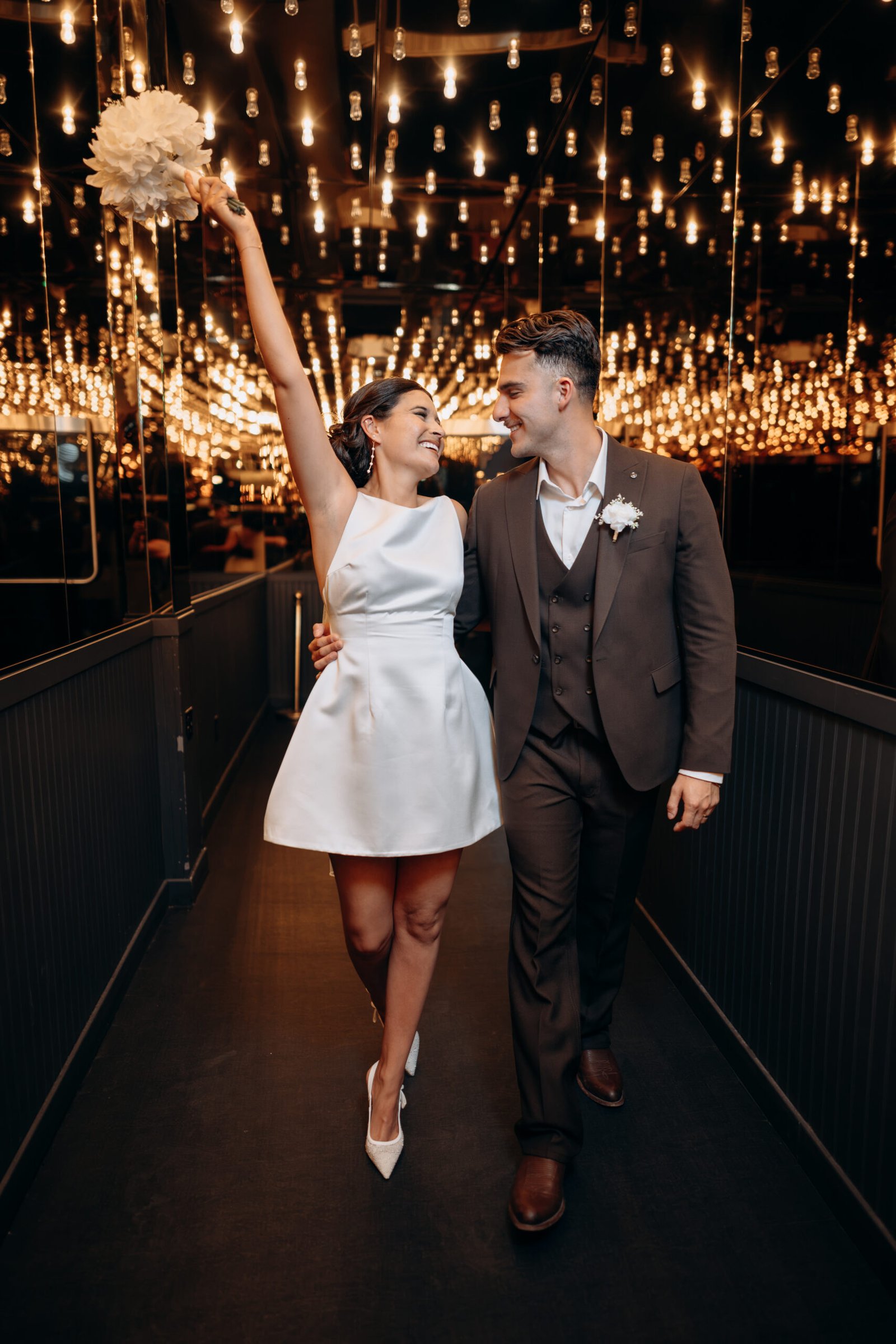 Young couple laughing together under the Fremont Street lights during their Las Vegas elopement